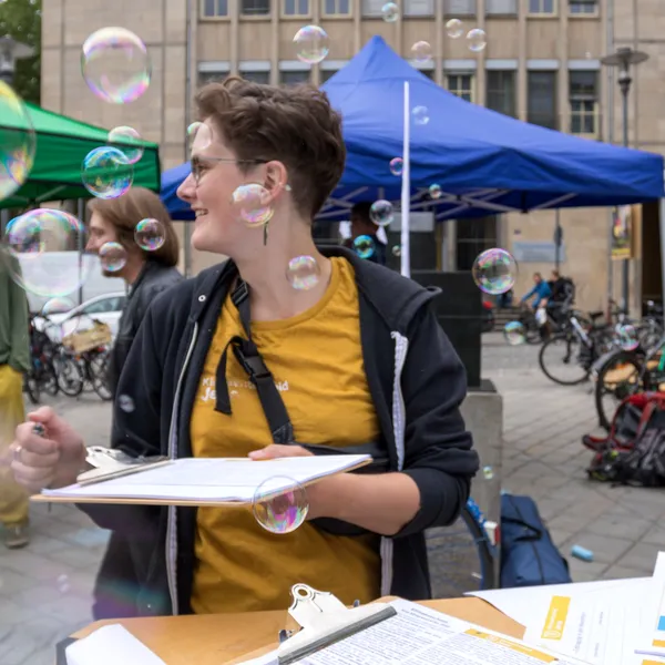 Hände halten Demoschild und Megaphon hoch